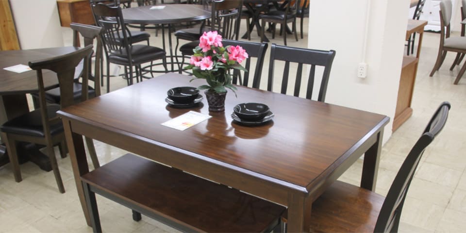 attractive dark hardwood dining room table with chairs, benches and glossy black vase and bowls